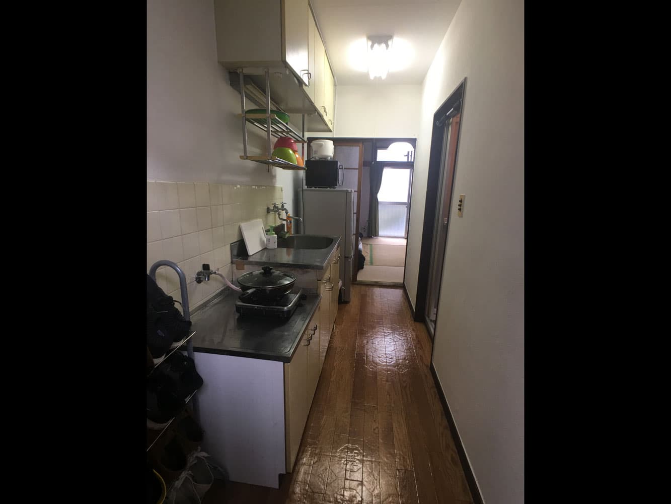 The cozy kitchen in this 1K apartment, with a stove, microwave, refrigerator, rice cooker, and more.